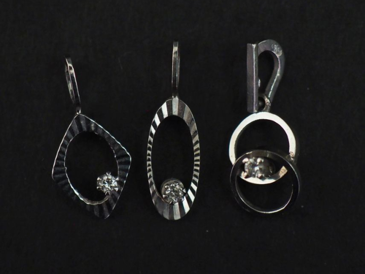 Ensemble comprenant :  - un pendentif ajouré de forme ovale en or blan