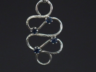 Vente aux enchères Pendentif de forme stylisée et ajouré en or blanc 750, serti de quatre