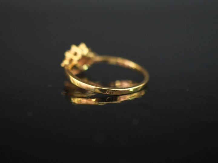Bague en or jaune 750, sertie en son centre d'une pierre rose entourée
