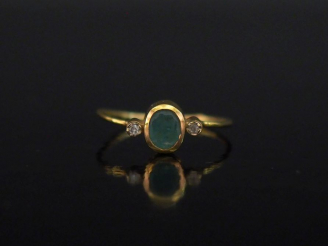 Vente aux enchères Bague en or jaune 750, sertie en son centre d'une émeraude épaulée de 