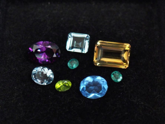 Vente aux enchères Ensemble de pierres précieuses et semi précieuses sur papier (émeraude