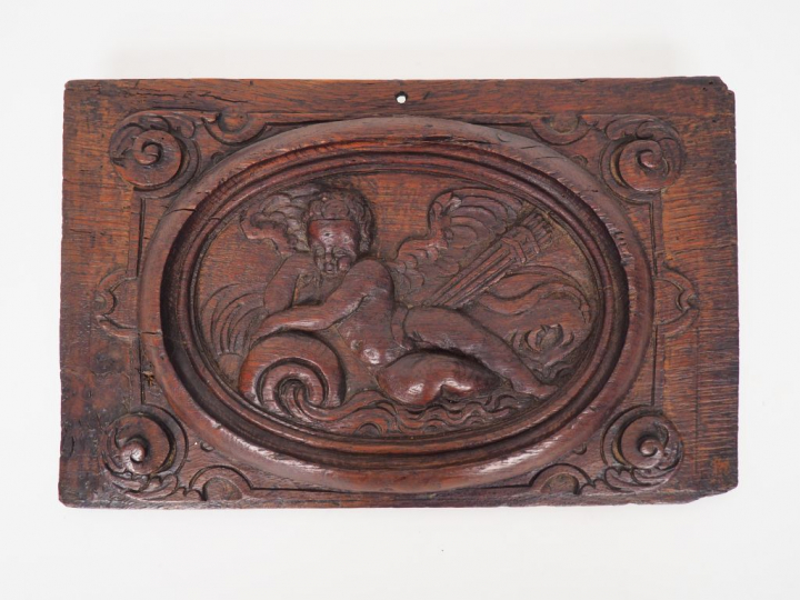 Panneau XVIIème en chêne sculpté à décor d'amour dans une mandorle ova