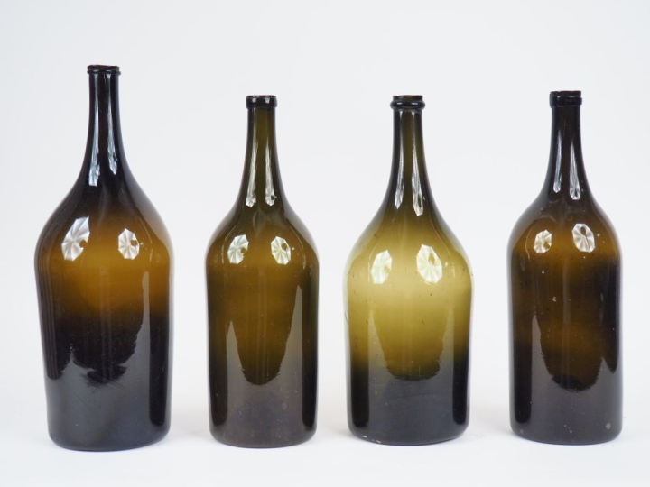 4 grandes bouteilles XIXème en verre fumé soufflé. H. 41 cm et 38 cm