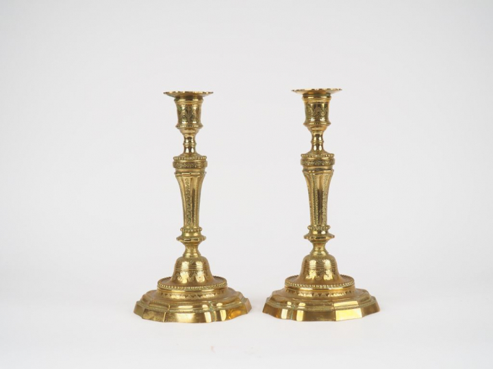 Paire de bougeoirs en bronze à décor gravé de feuillages avec leurs bo