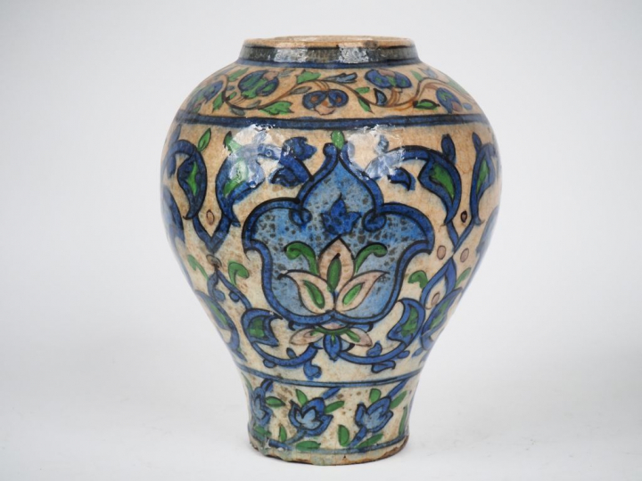Vase ovoide persan en céramique polychrome à décor de rinceaux feuilla