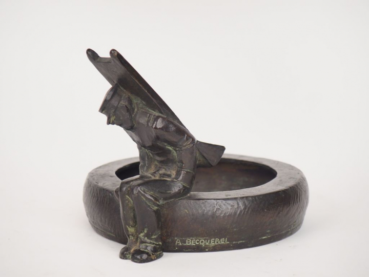 A. BECQUEREL.  Coupe en bronze figurant un colporteur assis sur un bas