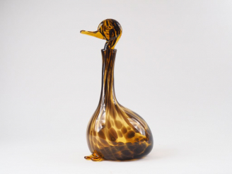 Vente aux enchères Verseuse en verre brun et ambré en forme de canard. H. 36 cm (égrenure
