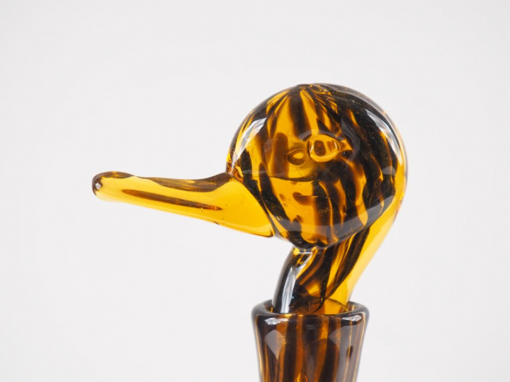 Verseuse en verre brun et ambré en forme de canard. H. 36 cm (égrenure