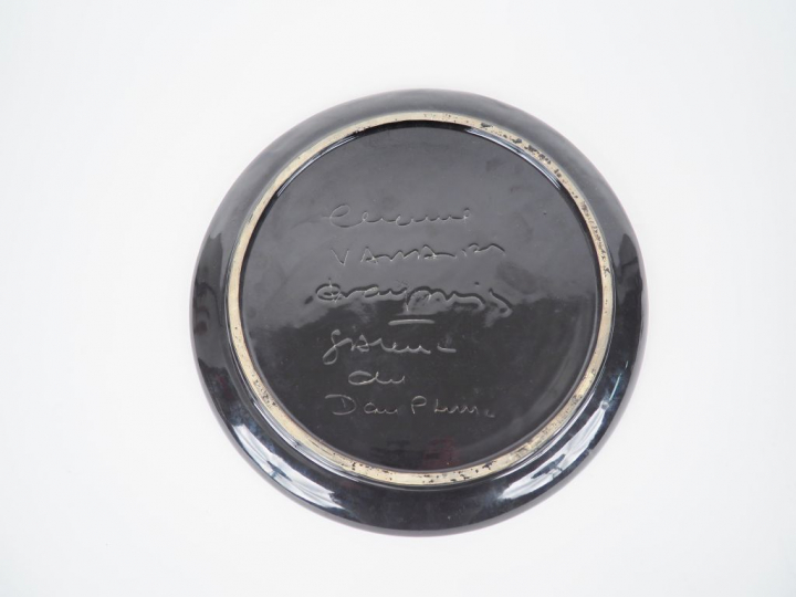 Plat 1960 en céramique polychrome à décor de jeune femme agenouillée. 