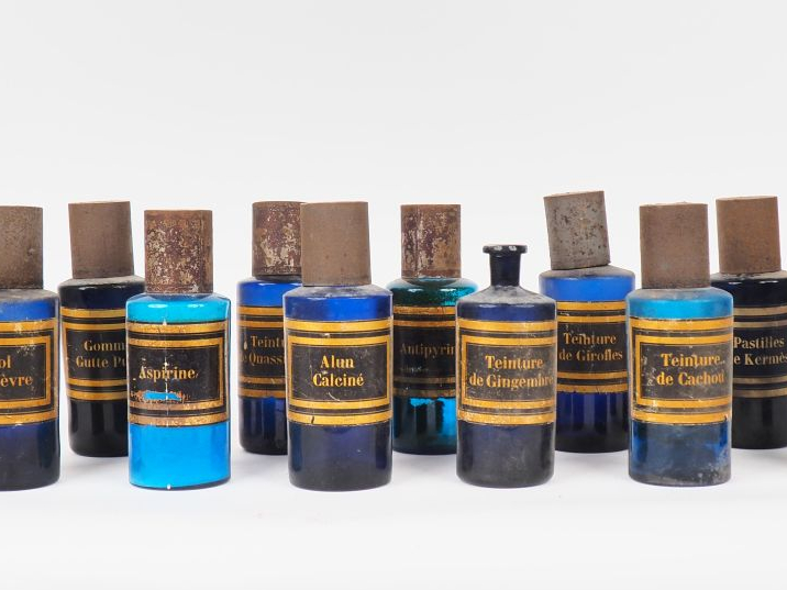 Ensemble de 24 pots de pharmacie en verre teinté et tôle, étiquette an