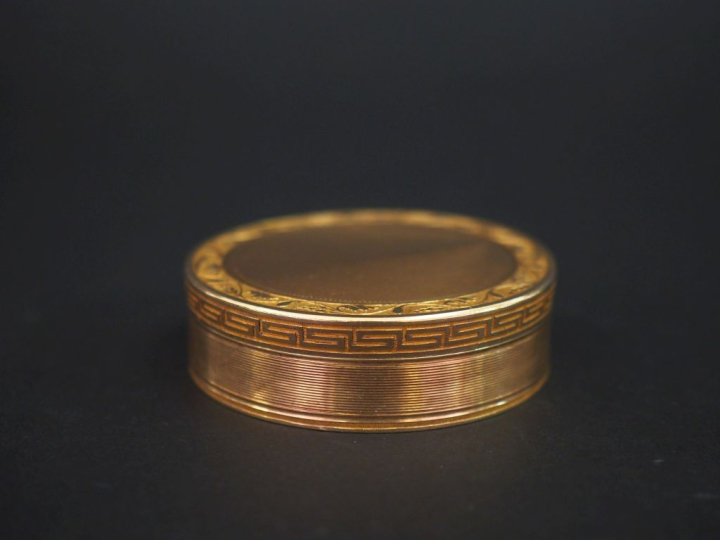 Boite ronde de style Louis XVI en or jaune 750, à décor de frise de ri
