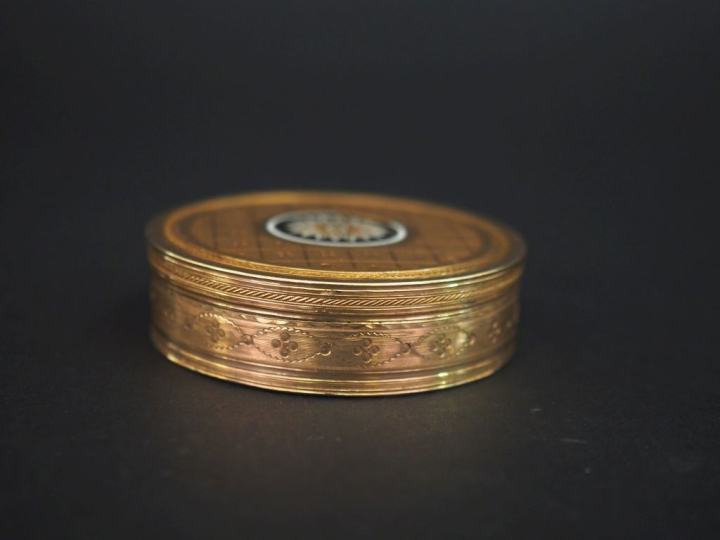 Boite ronde en or jaune 750, agrémentée d'émail noir et blanc, à décor