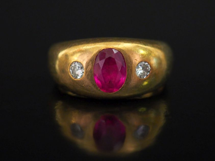 Bague bandeau en or jaune 750, sertie en son centre d'une pierre rouge