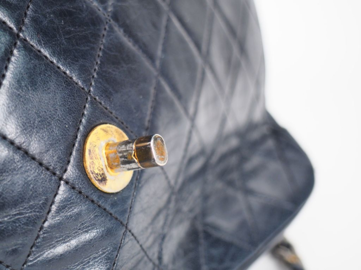 Sac bandoulière en cuir matelassé bleu.  Fermeture à rabat agrémentée 