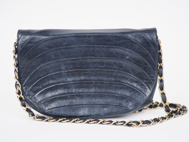 Sac bandoulière de forme besace en cuir bleu marine.  Fermeture à raba