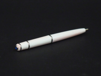 Vente aux enchères CARTIER Stylo bille en métal laqué blanc, agrémenté d'une pierre bleu 