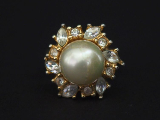 Vente aux enchères Christian DIOR,  Bague en métal doré, sertie en son centre d'une perle