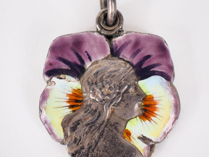 Pendentif Art Nouveau en métal argenté et émail polychrome figurant un