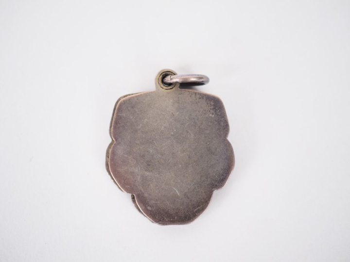 Pendentif Art Nouveau en métal argenté et émail polychrome figurant un