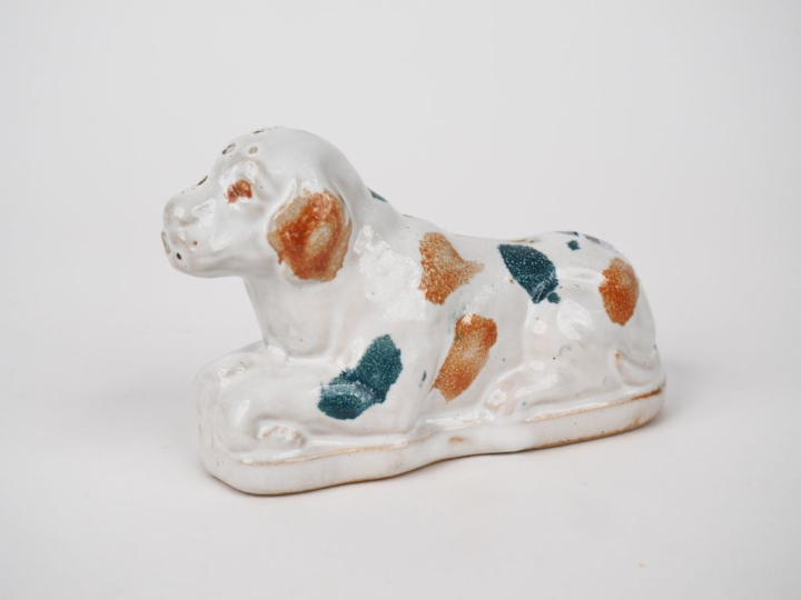 Tirelire en faïence polychrome en forme de chien assis. Dim. 9 x 14 x 