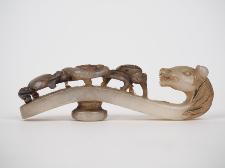 Chine XIXème. Fibule en jade céladon, extrêmité figurant une tête de c