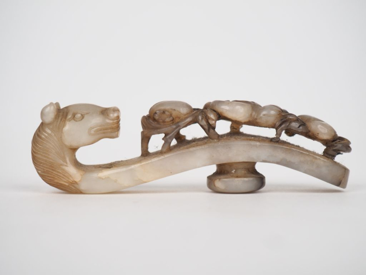 Chine XIXème. Fibule en jade céladon, extrêmité figurant une tête de c