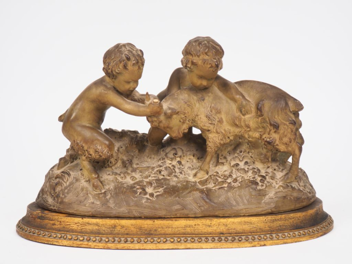 Groupe en terre cuite patinée "faunes jouant avec un bouc".  Dim. 23 x