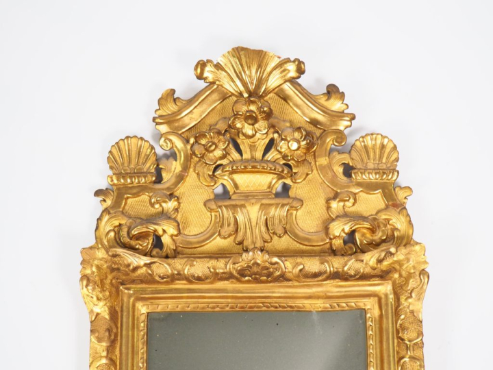 Miroir Louis XV en bois et stuc doré, à décor de rocaille et de fleuro