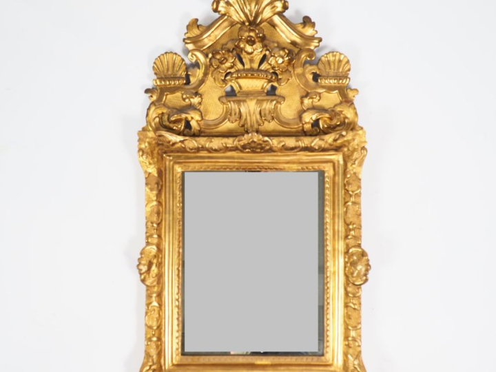 Miroir Louis XV en bois et stuc doré, à décor de rocaille et de fleuro