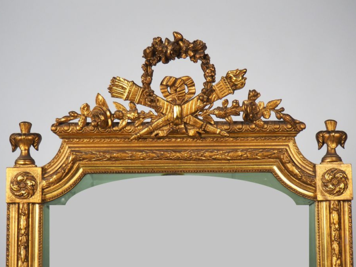 Glace Napoléon III de style Louis XVI en bois et stuc doré, à décor de