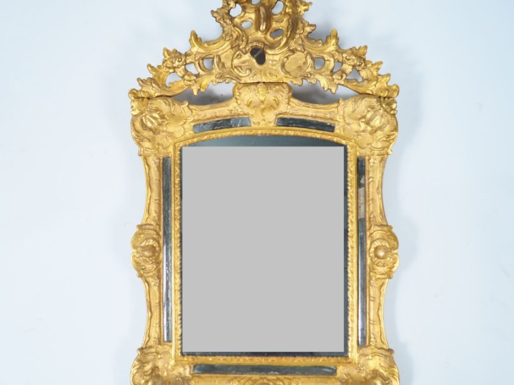 Glace Louis XV à parecloses en bois et stuc doré, à décor de cartouche