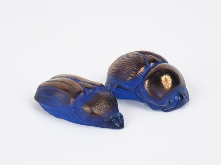 LALIQUE.  2 sujets en cristal bleu et irisé "scarabée". Signés Dim. 2 