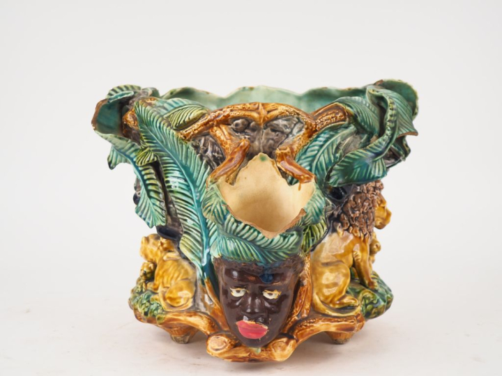 Grand cache pot en barbotine, à décor en relief de têtes d'africains e