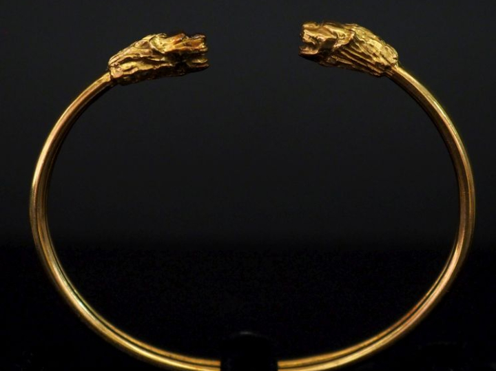 Bracelet jonc en or jaune 750, à décor de deux lions affrontés aux ext