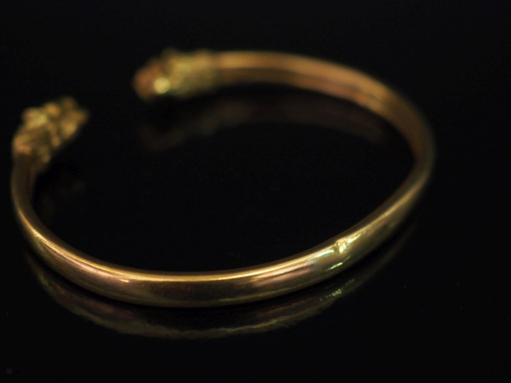 Bracelet jonc en or jaune 750, à décor de deux lions affrontés aux ext