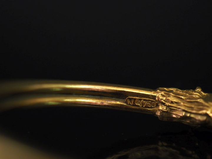 Bracelet jonc en or jaune 750, à décor de deux lions affrontés aux ext