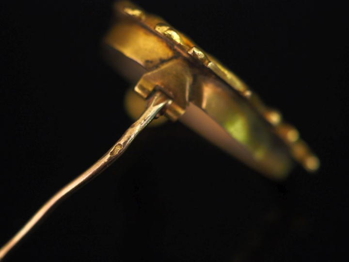 Broche en or jaune 750 en forme de coeur, à décor de rinceaux.  2,7 x 