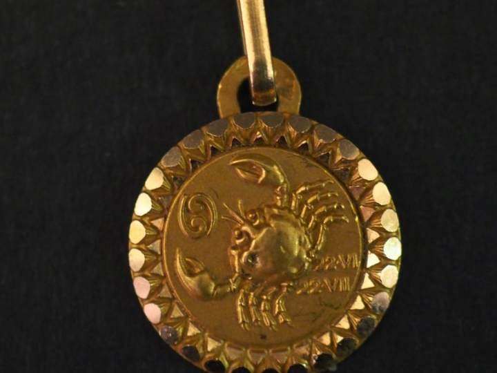 Pendentif circulaire en or jaune 750, à décor de signe astrologique.  