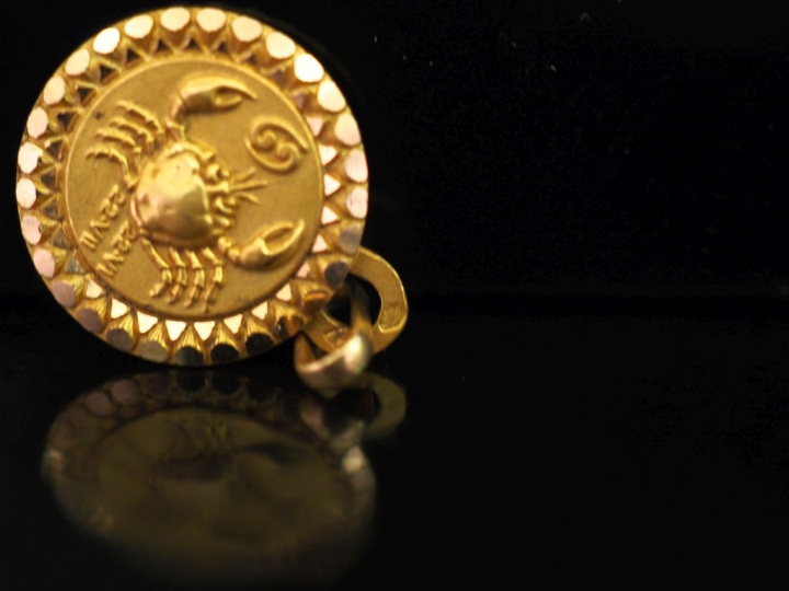 Pendentif circulaire en or jaune 750, à décor de signe astrologique.  