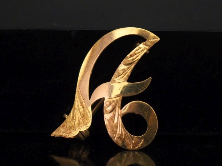 Petite broche de forme stylisée et ajourée en or jaune 750.  2,7 x 2 c