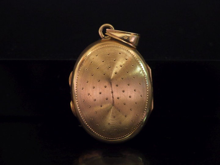 Pendentif porte-photo de forme ovale en or jaune 750, serti en son cen