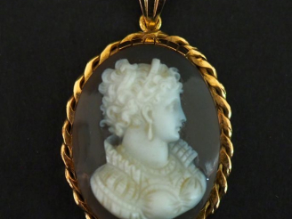 Vente aux enchères Pendentif ovale en or jaune 750, sertie en son centre d'un camée figur