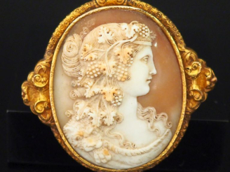 Vente aux enchères Importante broche en or jaune 750, sertie en son centre d'un camée fig