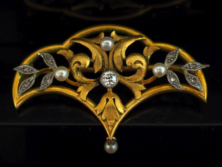 Broche 1900 en or jaune 750, à décor ajouré de feuillage et sertie de 