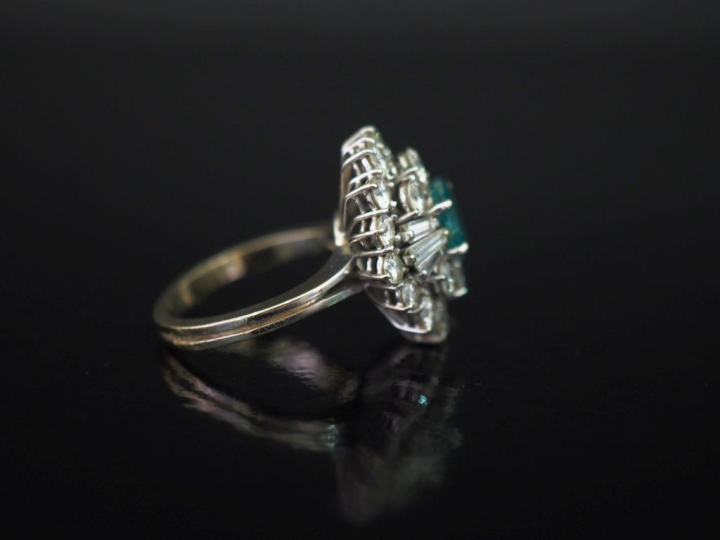 Bague de forme bombée en or blanc 750, sertie en son centre d'une émer