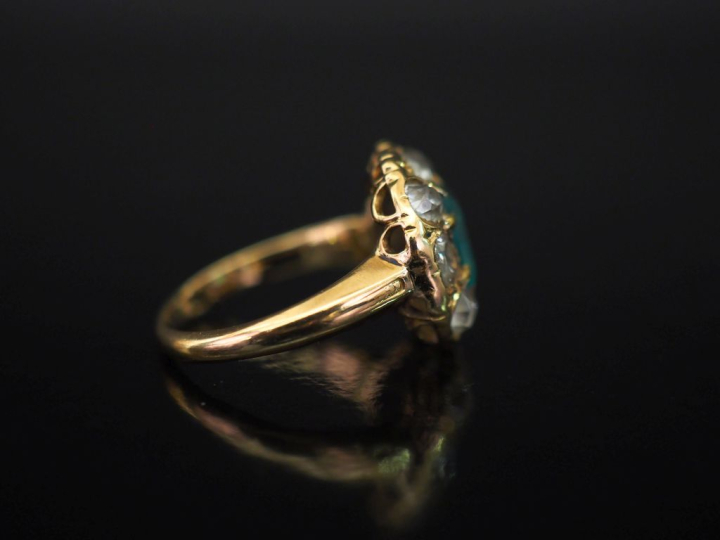 Bague en or jaune 750, sertie en son centre d'une émeraude et entourée