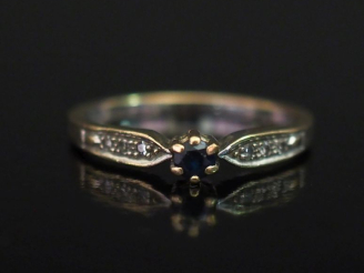 Vente aux enchères Bague en or blanc 750, sertie en son centre d'une pierre bleue épaulée