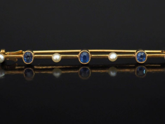 Vente aux enchères Broche barrette en or jaune 750, sertie de perles et saphirs alternés.