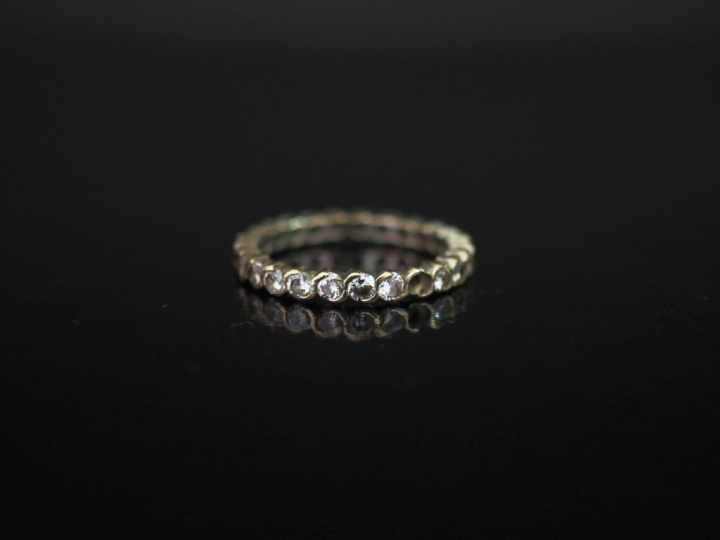 Alliance américaine en or blanc 750, sertie de petits diamants.  TDD. 