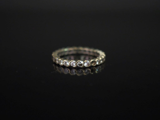 Vente aux enchères Alliance américaine en or blanc 750, sertie de petits diamants.  TDD. 